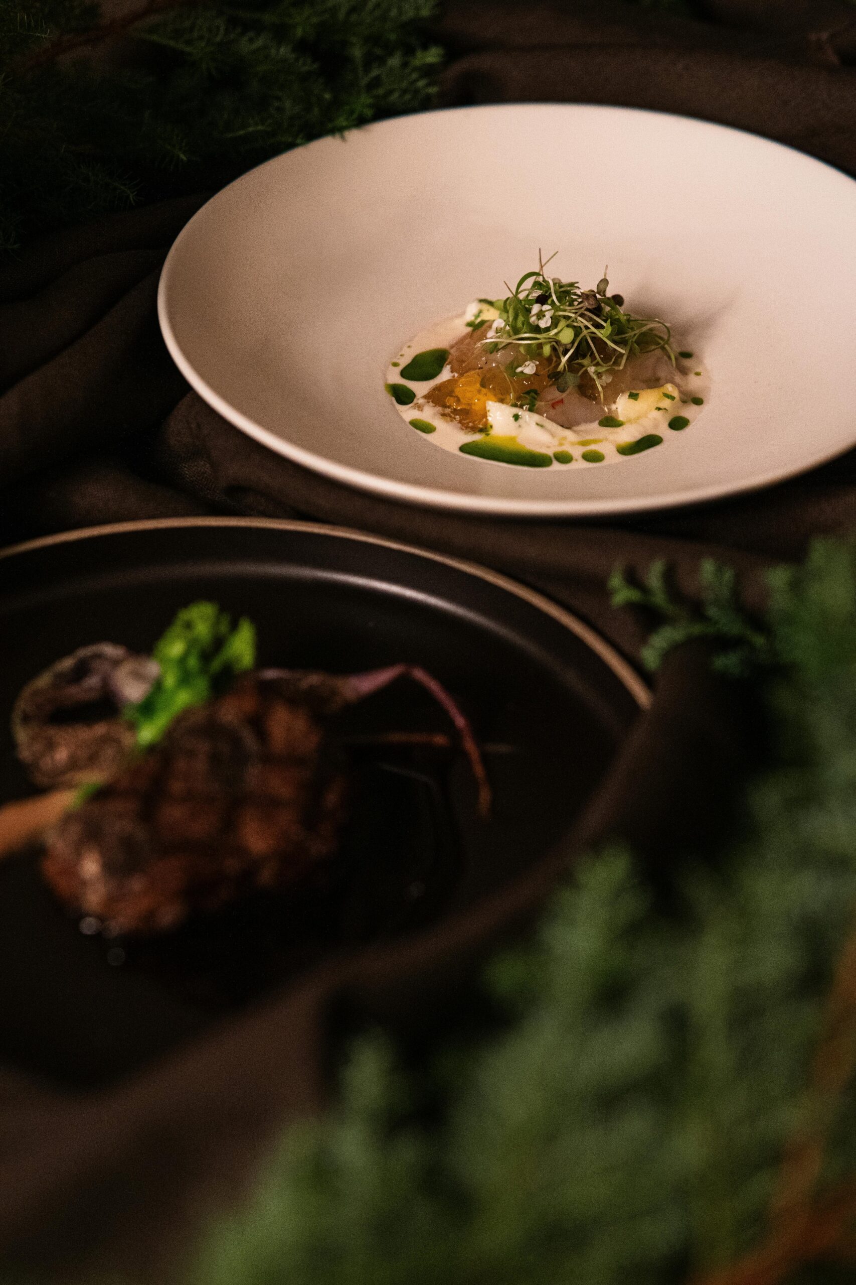 Close-up of elegantly plated fine dining dishes at a Tokyo restaurant, showcasing culinary artistry.